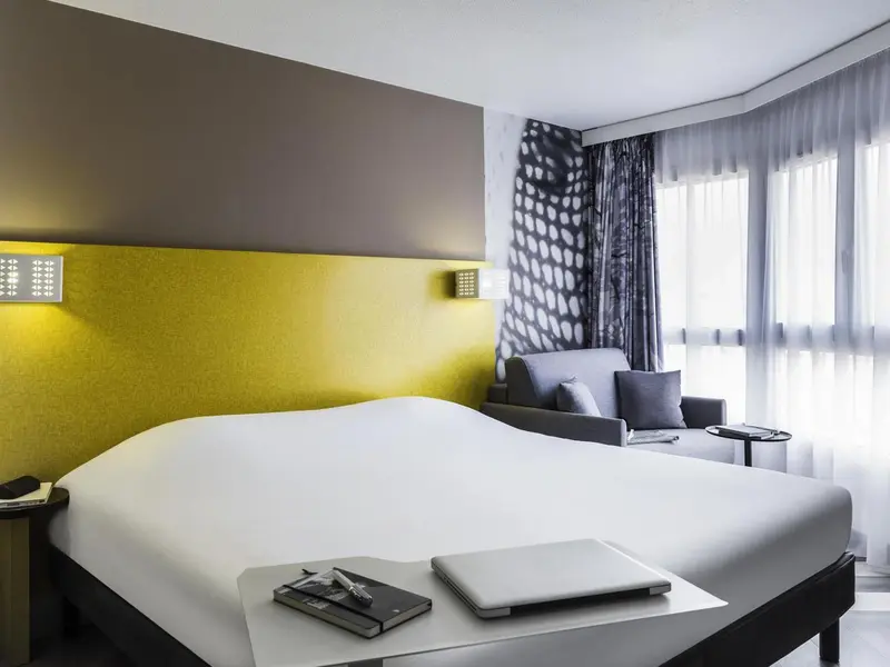 Une chambre d'hôtel moderne avec un grand lit et un canapé.