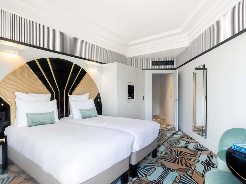 Une chambre lumineuse avec un grand lit et une décoration moderne.