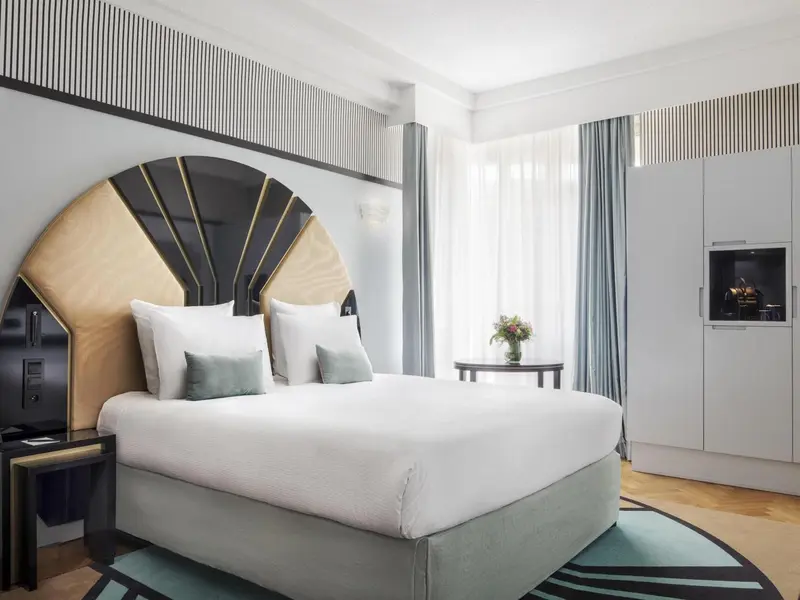 Une chambre lumineuse avec un grand lit et une décoration moderne.