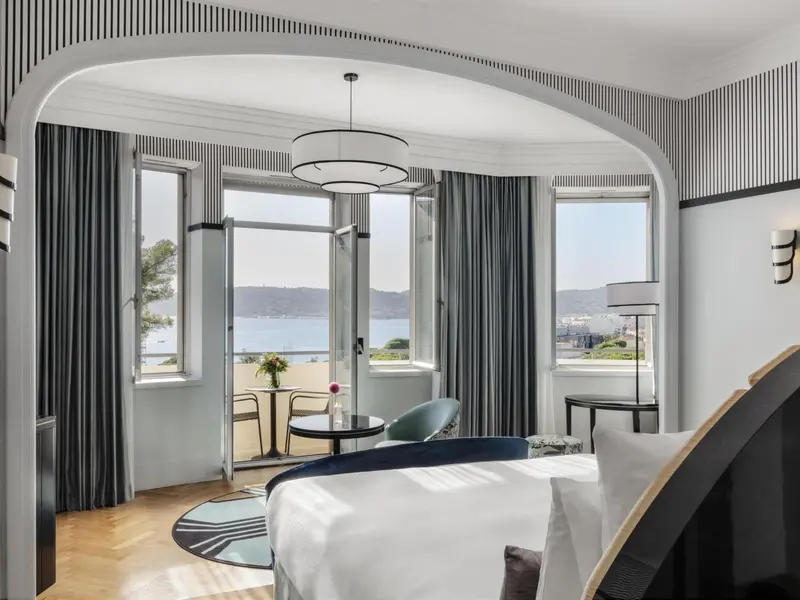 Chambre lumineuse avec vue sur la mer et mobilier contemporain.