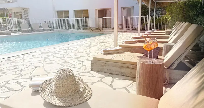 Transats et cocktail au bord d'une piscine ensoleillée.