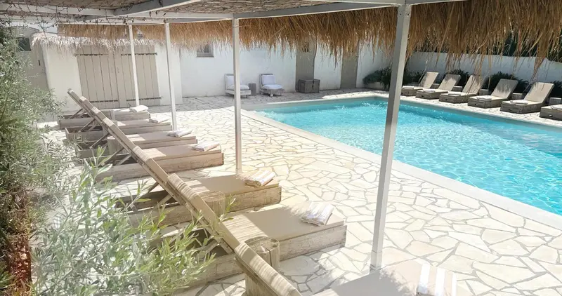 Transats alignés au bord d'une piscine ensoleillée.