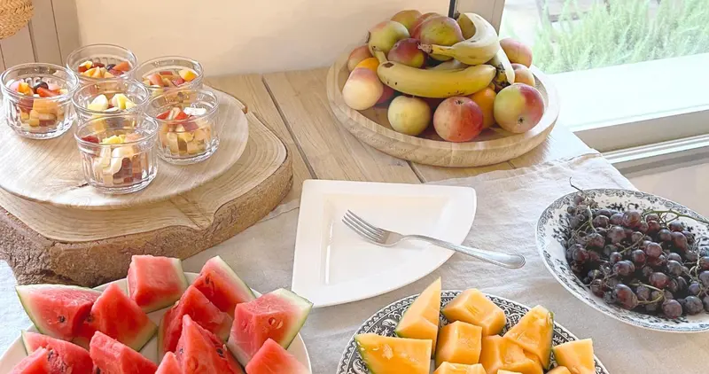 Une table garnie de salades de fruits frais et de melons.