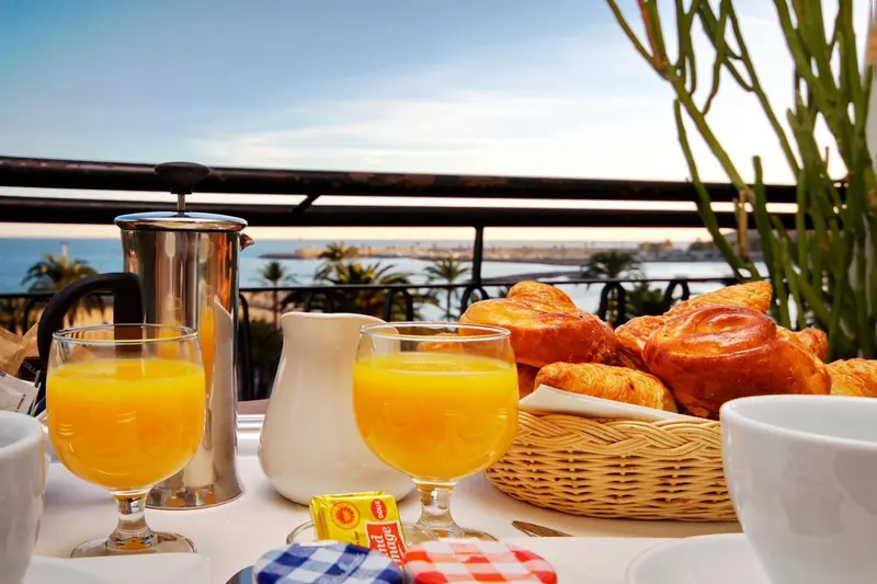 Un petit-déjeuner est servi sur une table avec vue sur la mer.