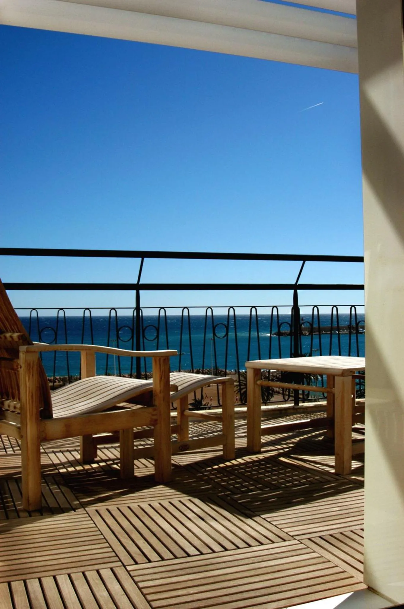 Terrasse en bois avec mobilier d'extérieur donnant sur la mer.