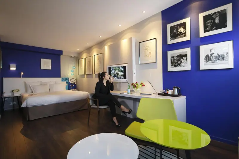 Une femme assise à un bureau dans une chambre d'hôtel moderne.
