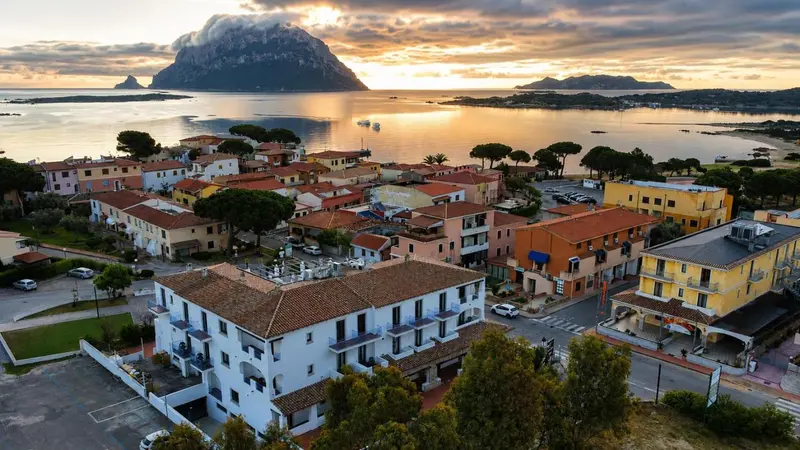 Vue aérienne d'un village côtier au coucher du soleil.