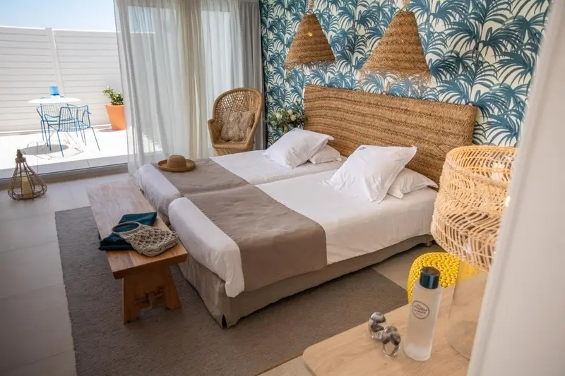 Une chambre lumineuse avec un grand lit et une décoration naturelle.