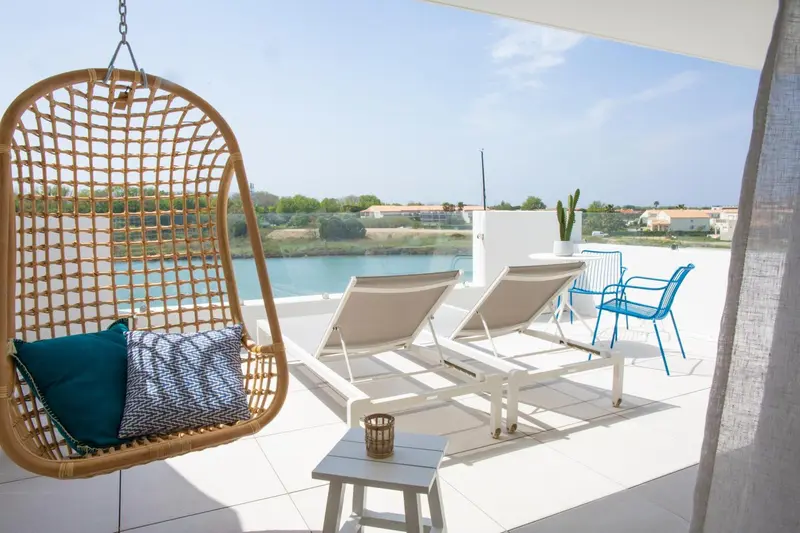 Espace de détente extérieur avec mobilier confortable et vue sur l'eau.