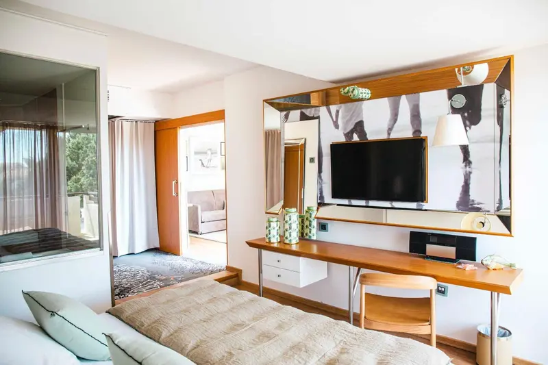 Une chambre lumineuse avec un grand lit et un bureau.