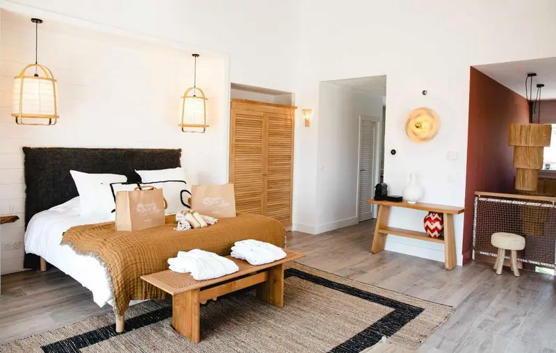 Une chambre lumineuse avec un grand lit et une décoration naturelle.