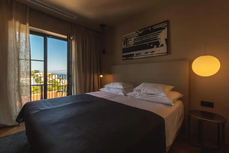 Une chambre avec un grand lit donnant sur une vue extérieure.