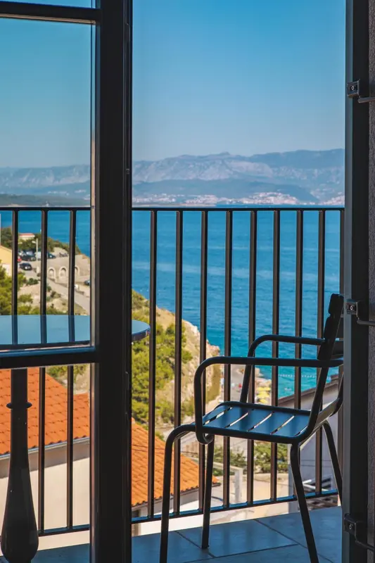 Vue sur la mer depuis un balcon avec mobilier.
