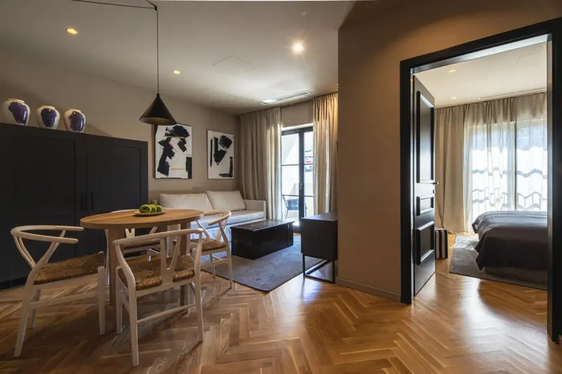 Espace de vie lumineux avec coin repas et accès à une chambre.