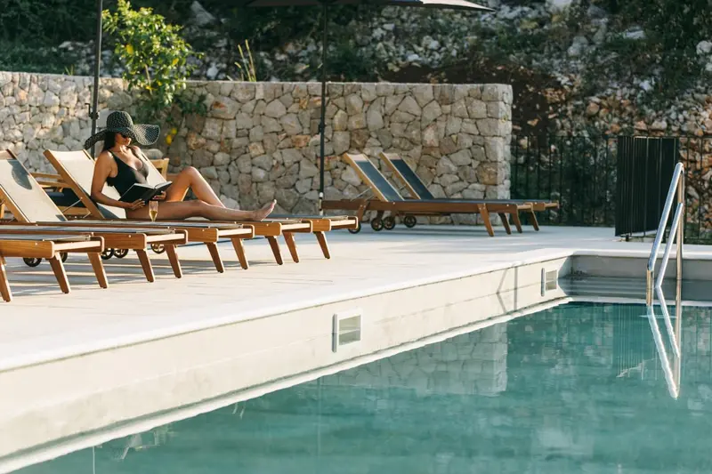 Transats alignés au bord d'une piscine ensoleillée.