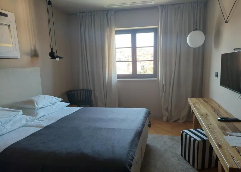 Une chambre lumineuse avec un lit et un bureau.
