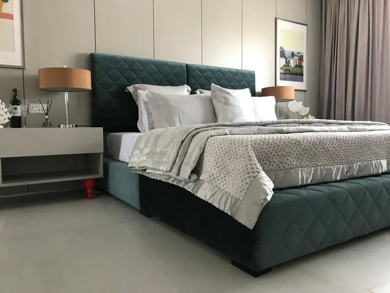 Une chambre spacieuse avec un grand lit recouvert d'une couverture claire.