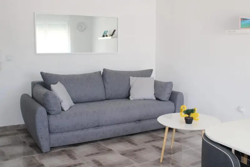 Un canapé gris et une table basse dans une pièce lumineuse.