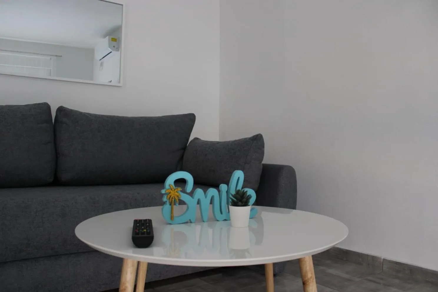 Un canapé gris et une table basse blanche ornent un espace de détente.
