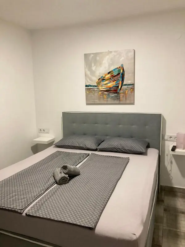 Une chambre avec un grand lit et une décoration murale représentant un bateau.