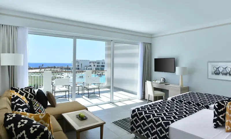 Une chambre lumineuse avec un canapé et un accès à une terrasse.