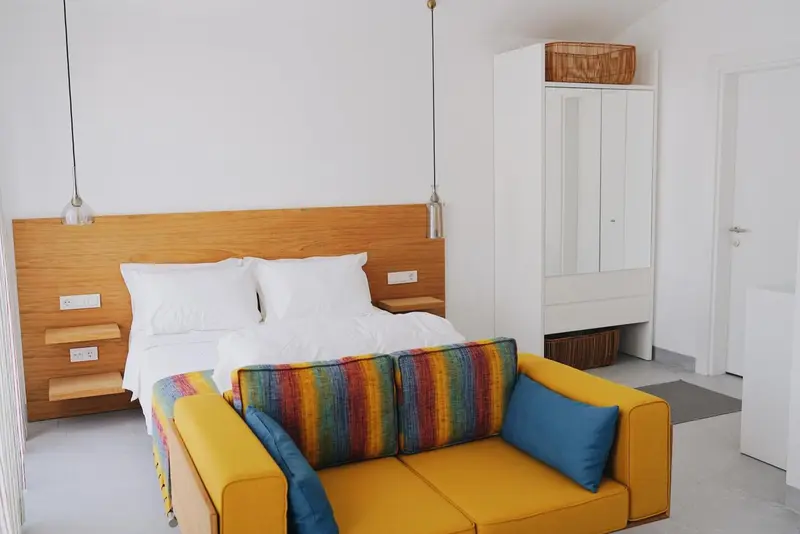 Une chambre lumineuse avec un lit et un canapé coloré.