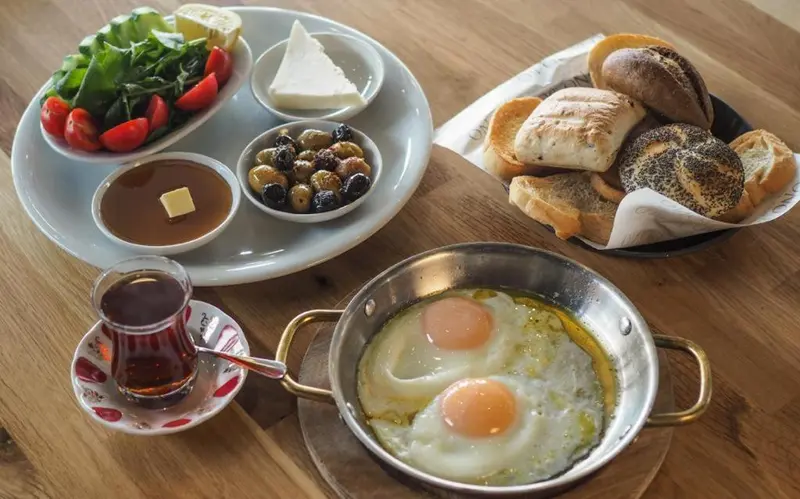 Assiette de nourriture avec œufs, pain, fromage et olives.
