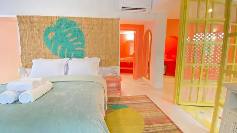 Une chambre colorée avec un grand lit et un décor tropical.