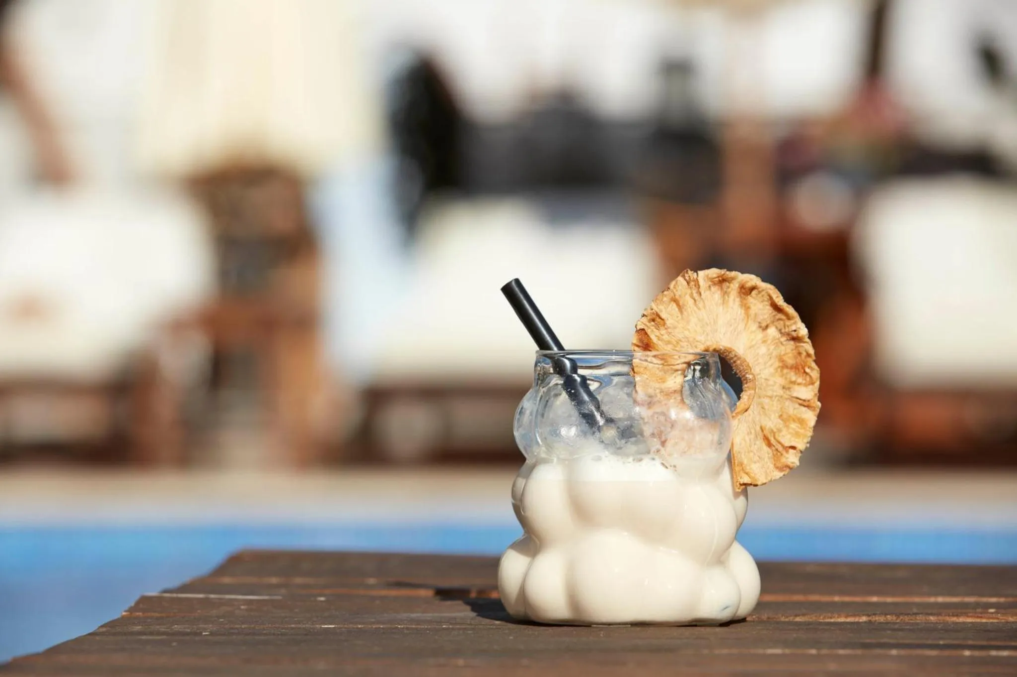 Un cocktail exotique est servi au bord d'une piscine ensoleillée.