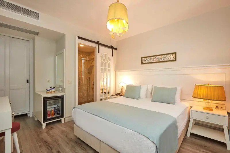 Une chambre lumineuse avec un grand lit et un coin repos.