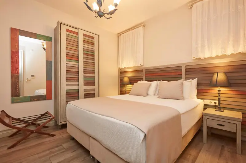 Une chambre lumineuse avec un grand lit et un miroir décoratif.