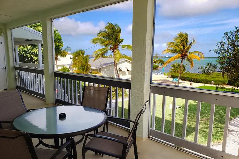 Terrasse avec mobilier de jardin donnant sur une vue tropicale.