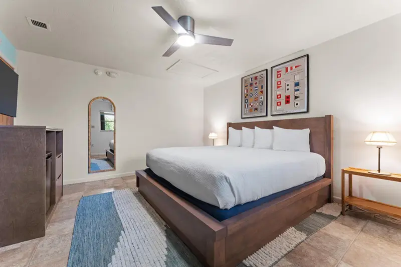 Une chambre lumineuse avec un grand lit et des tableaux décoratifs.