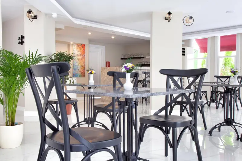 Une salle lumineuse avec des tables et des chaises pour les repas.