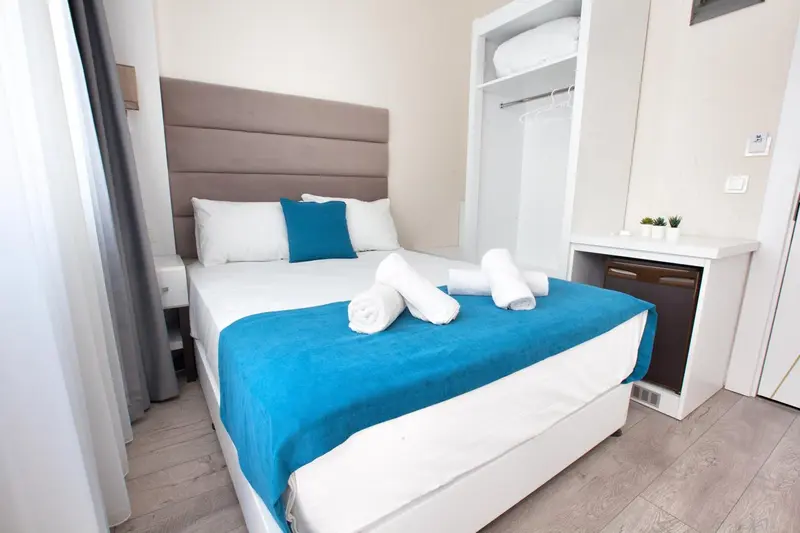 Une chambre avec un grand lit recouvert d'une courtepointe bleue et de coussins.
