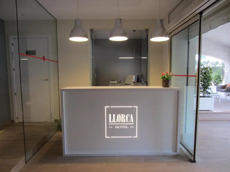 Un comptoir d'accueil moderne avec le nom de l'hôtel affiché sur le verre.