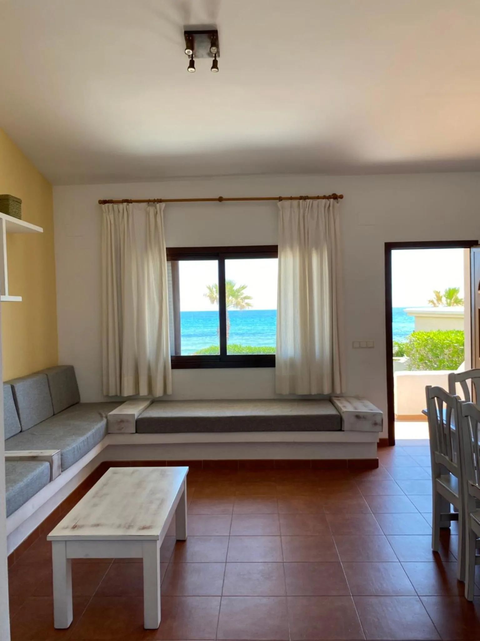 Espace de détente intérieur avec canapé et vue sur la mer.