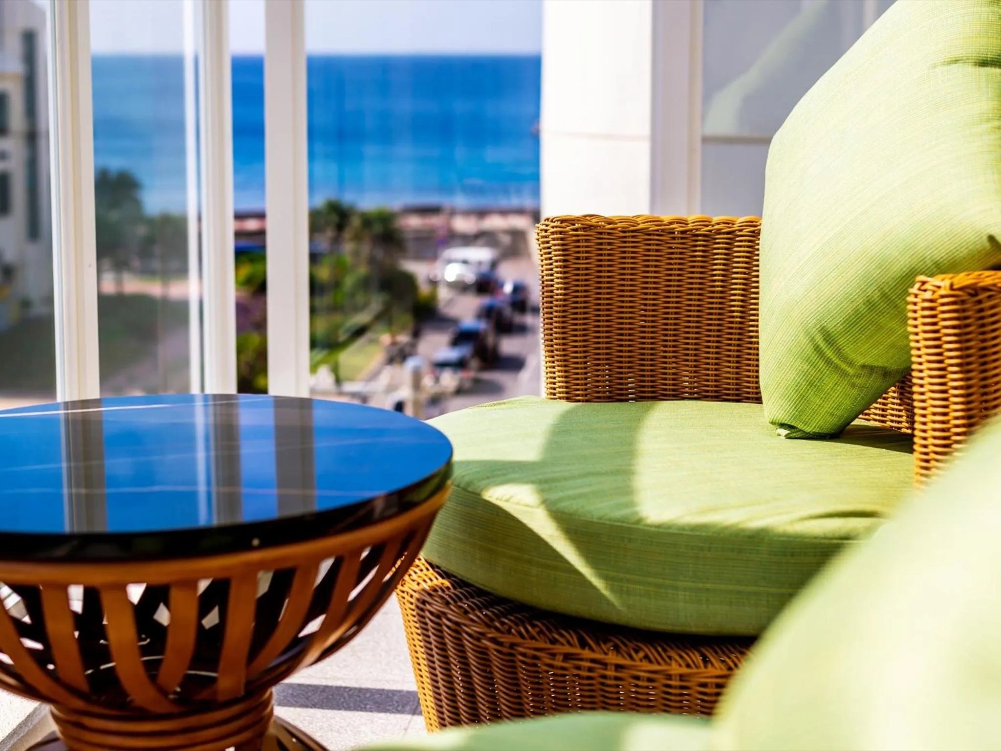 Un espace de détente avec mobilier en rotin et vue sur la mer.