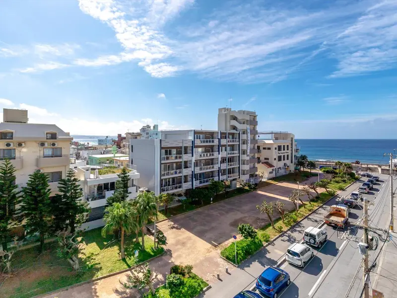 Vue aérienne d'un bâtiment blanc avec des balcons face à la mer.