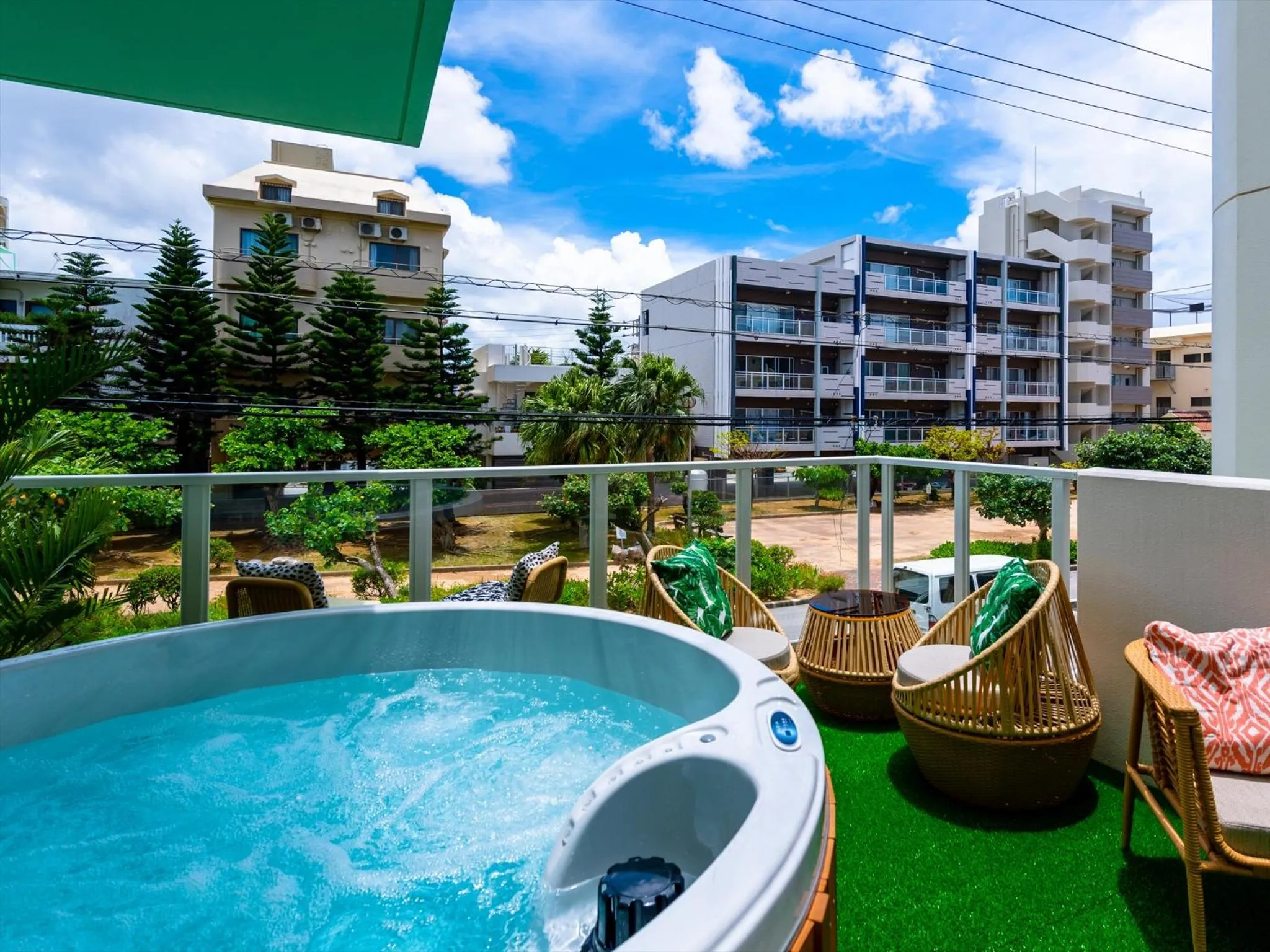 Un jacuzzi et des fauteuils de jardin invitent à la détente sur une terrasse ensoleillée.