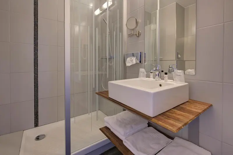 Une salle de bain moderne avec douche à l'italienne et vasque sur meuble.