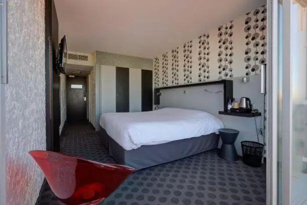 Chambre moderne avec un grand lit et une décoration graphique.