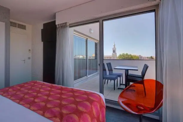 Une chambre lumineuse s'ouvre sur une terrasse avec vue sur la ville.