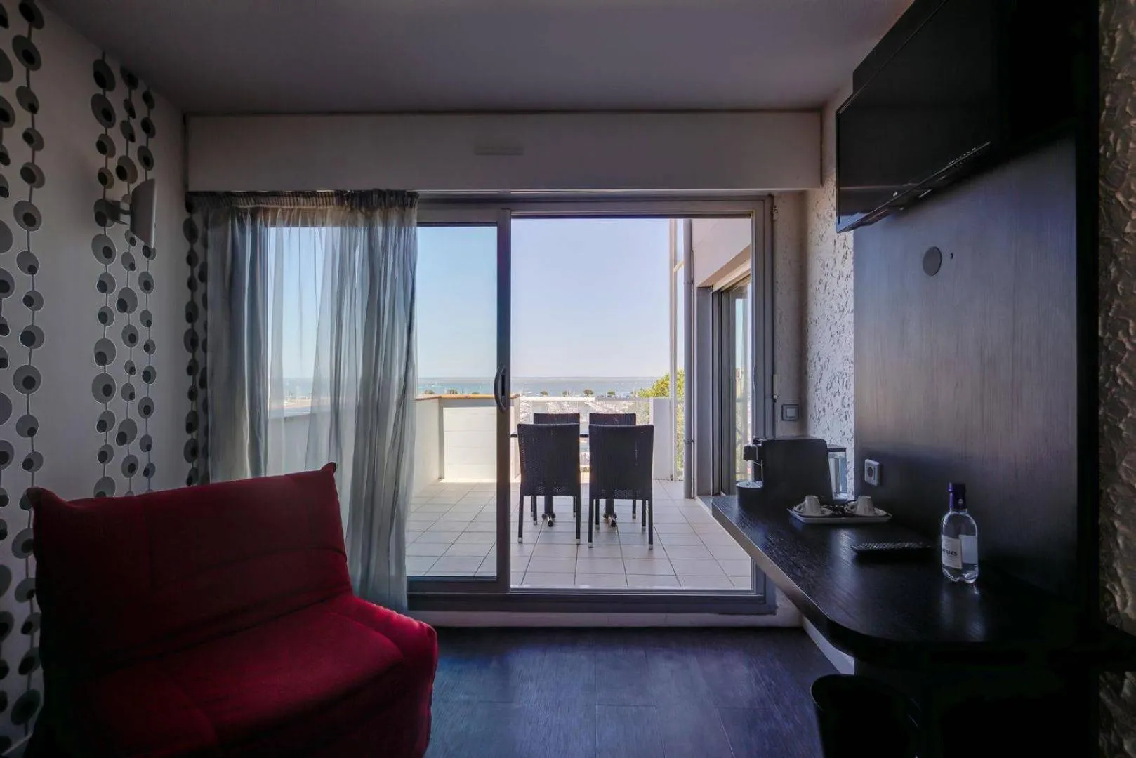 Une pièce lumineuse s'ouvre sur une terrasse avec vue sur la mer.