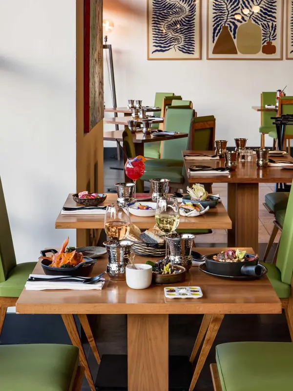 Une table de restaurant est dressée avec des plats et des boissons.
