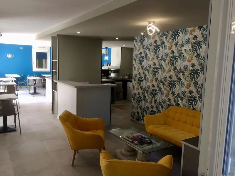 Un espace de détente avec canapés et fauteuils face à un comptoir.
