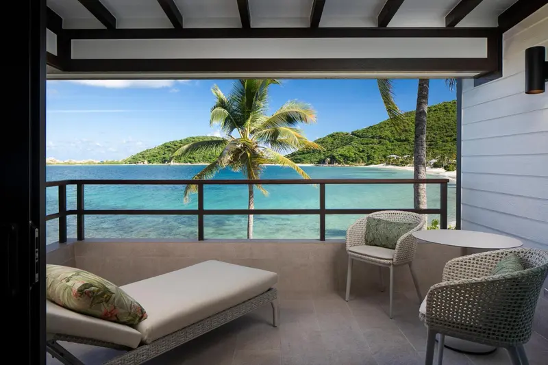 Terrasse avec mobilier d'extérieur donnant sur une plage et la mer.