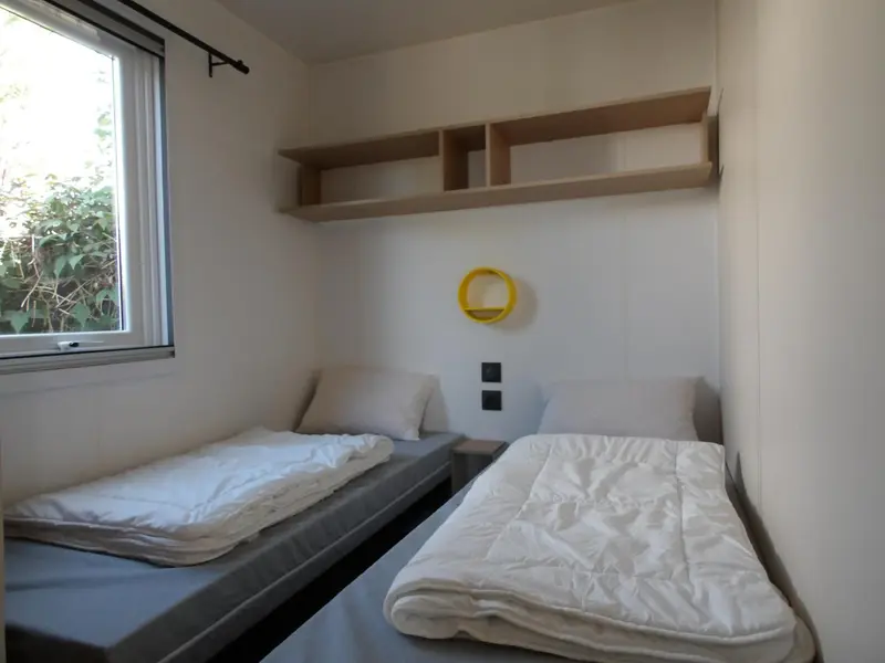Une chambre avec deux lits simples et une décoration minimaliste.