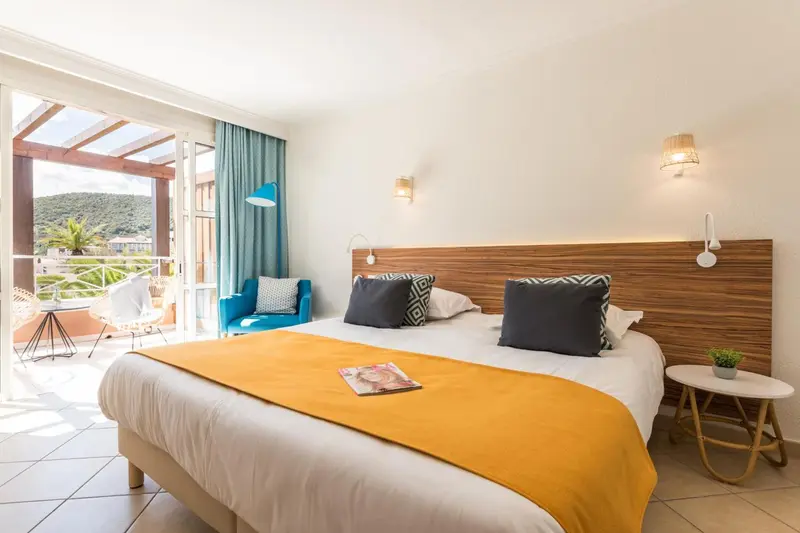 Une chambre lumineuse avec un grand lit et un accès à une terrasse.