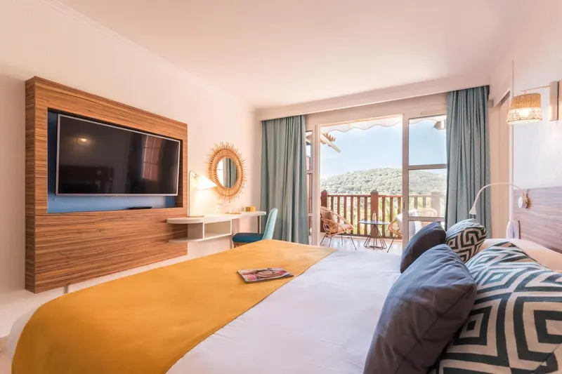 Une chambre lumineuse avec un grand lit et un accès à une terrasse.
